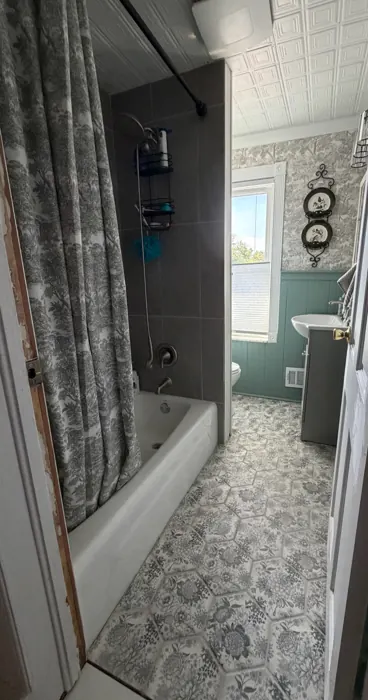 Second-floor bathroom with hex floor tile and tin ceiling